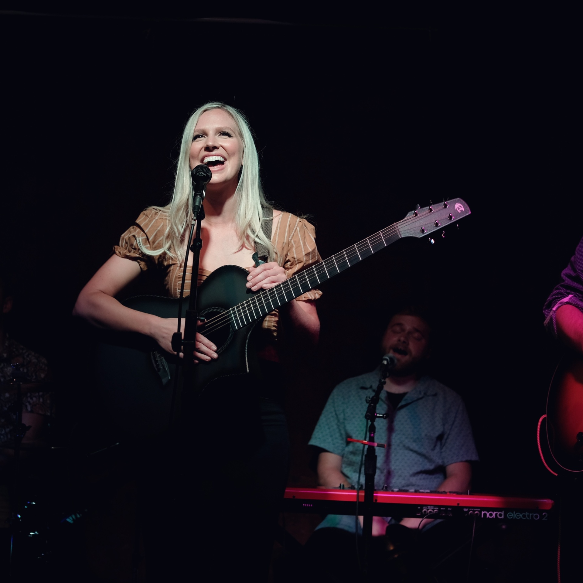 Christine performing on stage with guitar