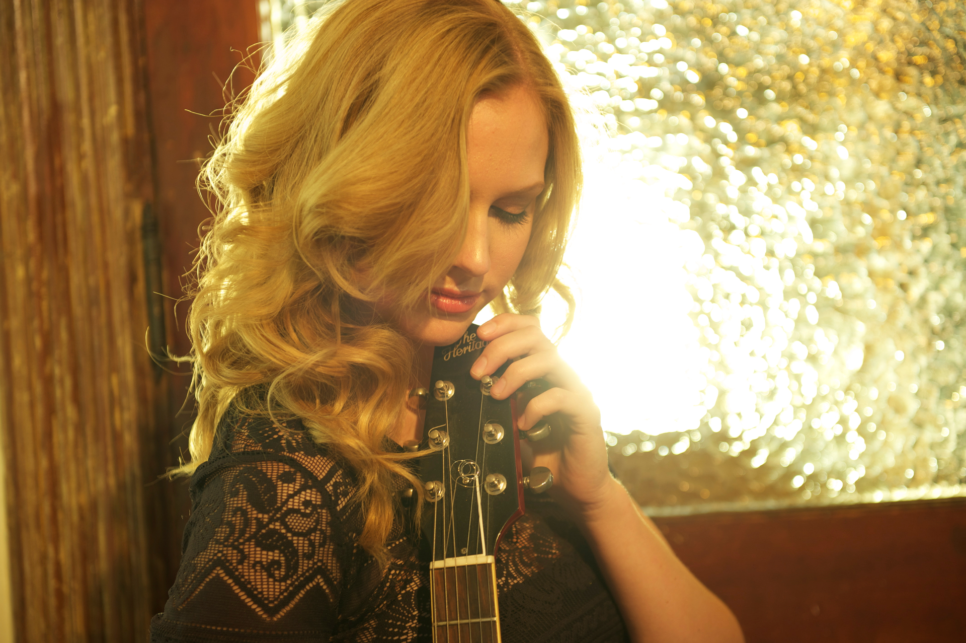 Christine with guitar in warm window light