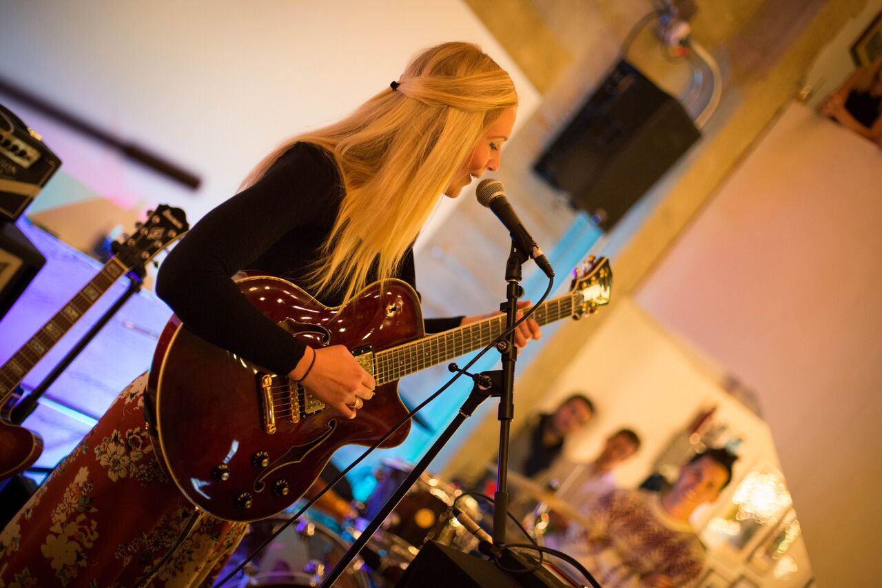 Christine playing a hollow-body electric guitar