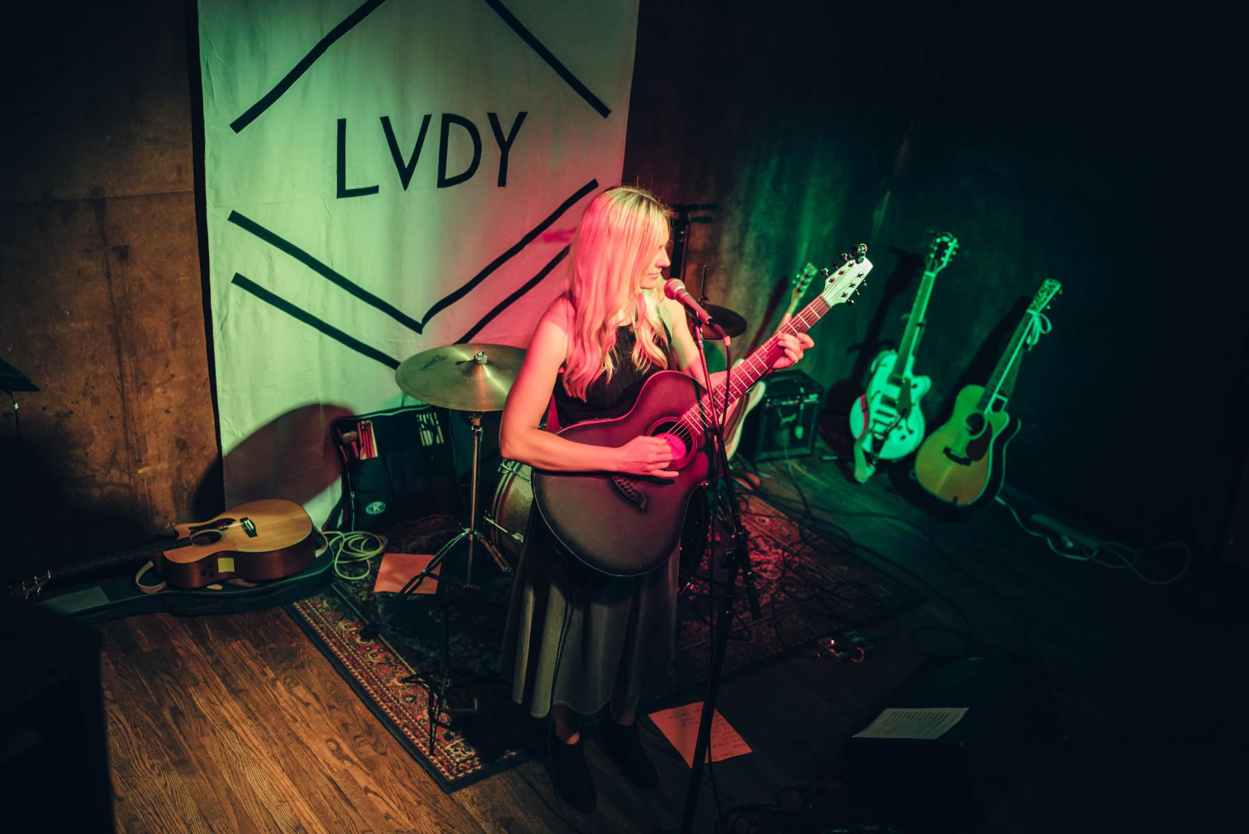 Christine performing solo with LVDY backdrop